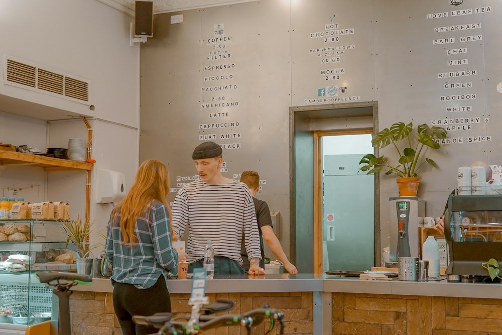Café owner talking with a customer at the counter